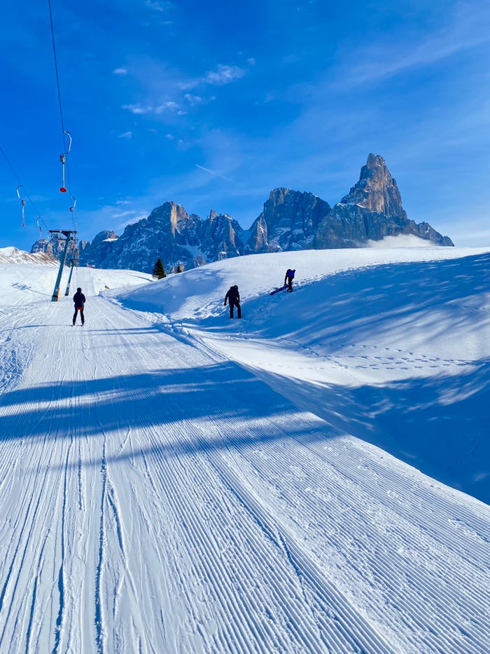 Beautiful ski slope in Dolomites with skiers and mountain view.