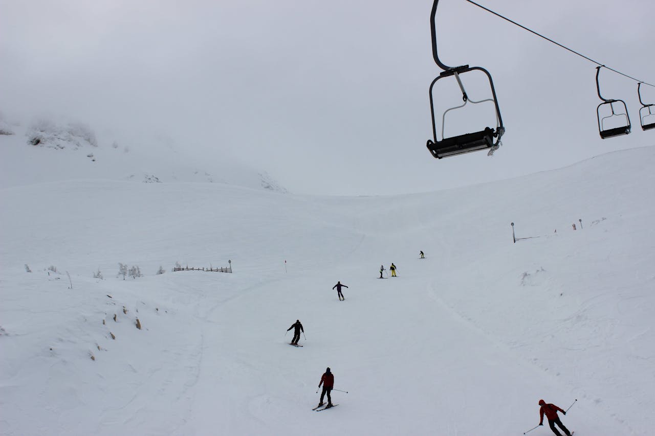Winter scene showcasing skiers on a snow-covered mountain with ski lifts.